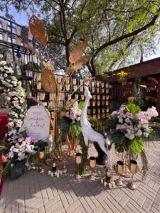 selfie-corner entrance setup, daytime wedding, outdoor event, floral decor
