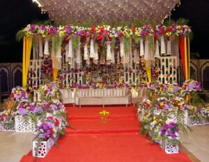 mehndi-stage indoor stage, floral decor, colorful backdrop, wedding designers